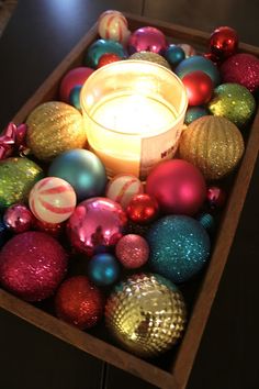 a candle sitting in a box filled with ornaments