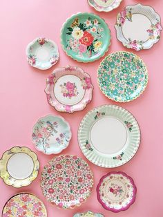 many plates are arranged on a pink surface