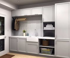 a laundry room with white cabinets and drawers