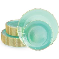 three plates stacked on top of each other with gold rims and green dishes in the middle