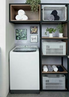 a small laundry room with blue walls and shelving