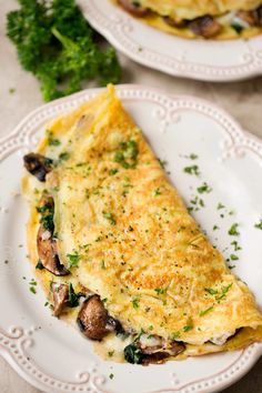 an omelet with mushrooms and parsley on a white plate next to another dish