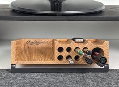 a turntable with wine bottles in it on top of a table