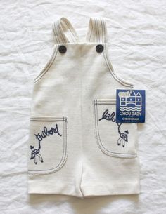 "FRENCH VINTAGE 70's, very cute short overalls / summer jumpsuit, cream textured jersey ( polyester and acrylic ), \" bâbord and tribord\" embroideries on pockets,navy blue overstitchings and buttons. Brand \" Chou Baby \". Size 2 years Vintage condition level 5, new old stock ( washed once ) We assess the condition of our vintage items on a scale from 0 to 5. Level 5 corresponds to an almost new vintage condition. Any defects are systematically reported. Even though in very good condition, vint Beige Cotton Overalls For Summer, Vintage White Jumpsuits And Rompers For Spring, Playful White Cotton Jumpsuits And Rompers, Playful Summer Jumpsuits And Rompers With Pockets, Cute White Overalls For Spring, Cute White Cotton Overalls, Cream Jumpsuits And Rompers With Pockets For Summer, Sleeveless White Cotton Overalls, Summer Cream Overall Jumpsuits And Rompers