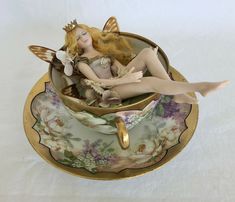 a fairy figurine sitting in a teacup