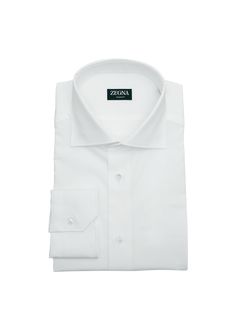 "Find ZEGNA Trofeo Cotton Dress Shirt on Editorialist. ZEGNA dress shirt crafted from fine, long cotton fibers for a silky smooth finish and added wrinkle-resistance Approx. 14\"L x 10\"W Spread collar; button placket Long sleeves Mitered barrel cuffs Yoked back shoulders Shirttail hem Classic fit Item Weight (Lbs.): 0.6 Cotton Imported" Elegant Collared Dress Shirt With Placket, Spring Formal Dress Shirt With Concealed Placket, Elegant Spring Dress Shirt With Concealed Placket, Elegant Shirt With Covered Buttons And Fold Down Collar, Luxury Collared Shirt With Button Cuffs, White Cuff Shirt For Semi-formal Occasions, Formal Summer Shirt With Buttons, Elegant Collared Dress Shirt With Covered Buttons, Business Shirt With Fold Down Collar For Summer