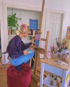 an older woman is painting in her studio