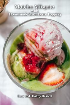 a bowl filled with ice cream and strawberries on top of a white tablecloth