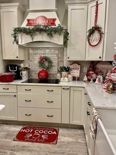 a kitchen decorated for christmas with red and white decor