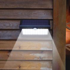 a close up of a light on the side of a wooden building with wood siding