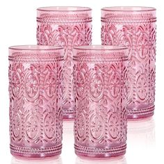 four pink glass tumblers sitting next to each other