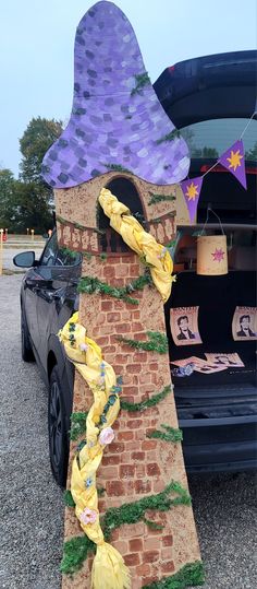 a brick tower with a purple hat on it's top and yellow scarf around the base