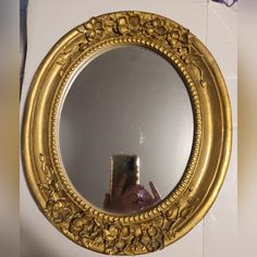 a person taking a selfie in front of a gold framed mirror with flowers on it