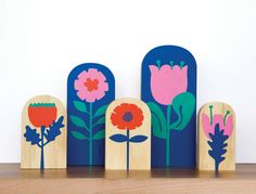 wooden blocks with flowers on them sitting on a shelf