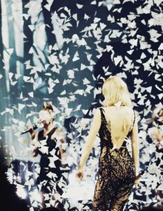 a woman standing in front of a wall with butterflies on it's back end