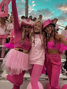 three girls dressed in pink posing for the camera