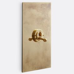 a gold door handle on a white wall