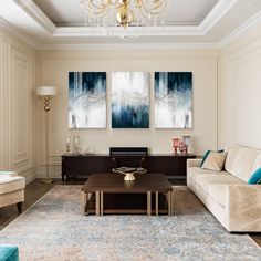 a living room filled with furniture and a chandelier hanging above the couches