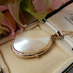 An exceptional vintage 9ct rolled gold locket with chain. This unique oval shaped locket has an eye catching mother of pearl plaque on front - the lustre and color of the shell panel is really special, we hope that the photos do it justice. This locket comes with a new gold filled gold chain making it ready to wear right away. This locket is perfect for storing a precious keepsake inside such as a photo or a lock of hair.  A unique true vintage & personal piece of jewellery! This Locket comes pr Elegant Cameo Jewelry Keepsake, Elegant Cameo Keepsake Jewelry, Antique Oval Pearl Pendant Jewelry, Elegant Cameo Locket Necklace For Wedding, Elegant Oval Cameo Locket Necklace, Vintage Locket Necklace With Polished Finish For Anniversary, Shell Locket, Lock Of Hair, Marvel Gifts