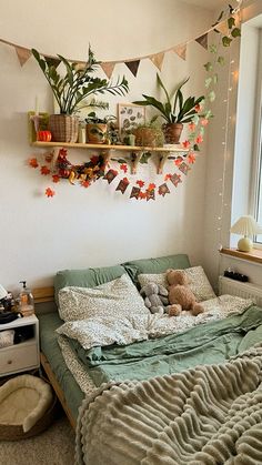 a bedroom with a bed, shelves and plants on the wall above it in front of a window