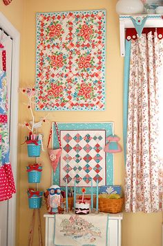 a room filled with lots of different types of quilts and decor on the walls