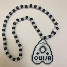 a beaded necklace with a white and black object on it