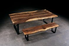 two wooden benches sitting on top of a cement floor in front of a black wall