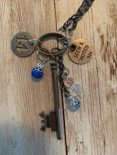 "A lovely set of charms hang off of a vintage style skeleton key. Each of the items and it's jump rings are in a variety of metal finishes. They hang off of a 13\" black stainless, box-like chain which could be adjusted if you would like. The variety of charms include two round tags; one with the sentiment, \"Seen and Noted\" engraved into it and an openwork number \"14\". The other charms are beads; two of which dangle from their own piece of chain and one which hangs on its own. Remember, this is a handmade item and can be quite delicate. This is not a toy. This is not intended for children; it is made from small parts and poses a safety hazard. Please use it only for its intended purpose and under strict adult supervision. Please examine all of the photos and be sure that this is the it Metal Jewelry With Keys For Gifts, Metal Key Pendant Jewelry, Key Pendant Jewelry In Metal, Vintage Pendant Jewelry With Keys, Key Detail Metal Jewelry As A Gift, Metal Key Necklace Perfect As Gift, Vintage Personalized Metal Charm Necklace, Vintage Metal Jewelry With Keys Detail, Vintage Metal Jewelry With Keys