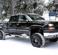 a large black truck parked in the snow