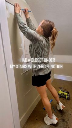 a woman is painting the wall with paint rollers and writing on it that says, i had a close under my stairs with zero function