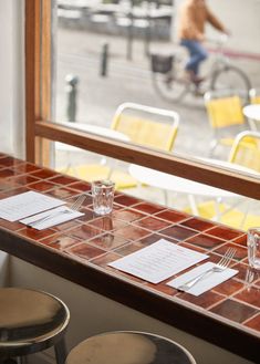 two empty glasses are sitting on the table in front of a man riding a bike