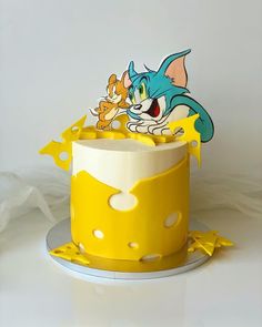 a yellow and white cake with an image of cat in the hat sitting on top of it