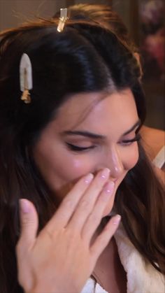 a woman with her hands on her face looking at something in front of her mouth