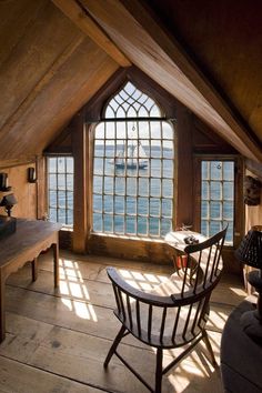 a room with two windows and a desk in front of the window is a boat