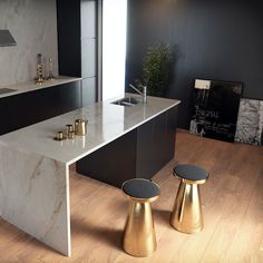 a modern kitchen with marble counter tops and gold stools