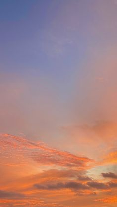 an airplane is flying in the sky at sunset