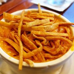 a white bowl filled with french fries on top of a table