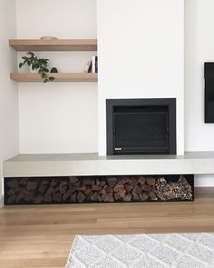 there is a fireplace in the living room with wood stacked on it's sides