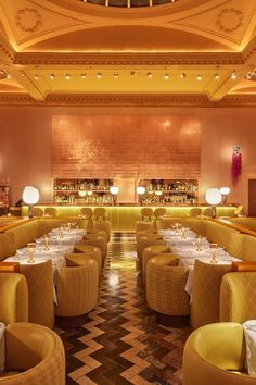 the interior of a fancy restaurant with yellow chairs and white tablecloths on tables