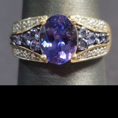 R265. $389 Size7. 1.43ct Oval Tanzanite With .93ctw Round Blue Tanzanite And .23ctw Round White Diamond 10k Yellow Gold Ring. 3.0grams. Measures Approximately 3/8"L X 1/16"W. Never Worn. Est Retail Value: $944.00. Made In Thailand. Tanzanite Jewelry With Accent Stones For Anniversary, Tanzanite Gemstones With Gemstone Accents For Anniversary, Classic Tanzanite Multi-stone Jewelry, Anniversary Tanzanite Sapphire Ring With Gemstone Accents, Tanzanite Rings With Gemstone Accents For Anniversary, Tanzanite Gemstones For Anniversary, Classic Tanzanite Gemstones For Anniversary, Tanzanite And Diamond Ring, Tanzanite Diamond Ring