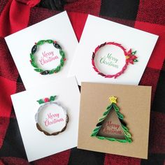 three christmas cards with the words merry christmas written on them and a small tree made out of paper