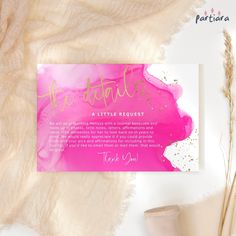 a pink and gold foiled business card on top of a table