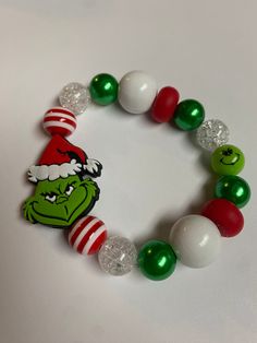 the grinch bracelet is decorated with green, white and red beads