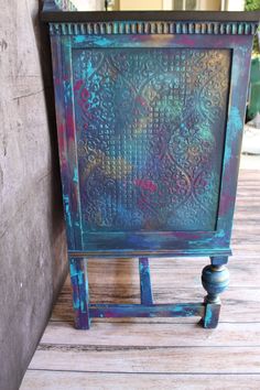 an old blue painted cabinet sitting on top of a wooden floor next to a wall