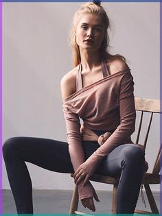 a woman is sitting on a chair with her legs crossed and wearing leggings