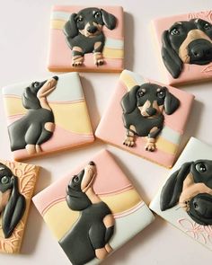 four decorated cookies with dogs on them sitting next to each other in the shape of squares