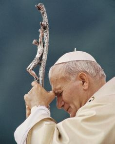 a close up of a person holding a metal object in front of his face and hands