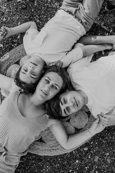 three people laying on the ground with their arms around each other