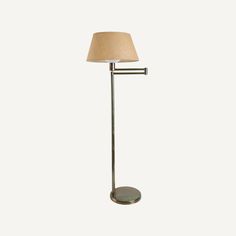 a floor lamp with a beige shade on the top and bottom part of it's arm