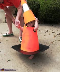 a young child wearing an orange cone costume